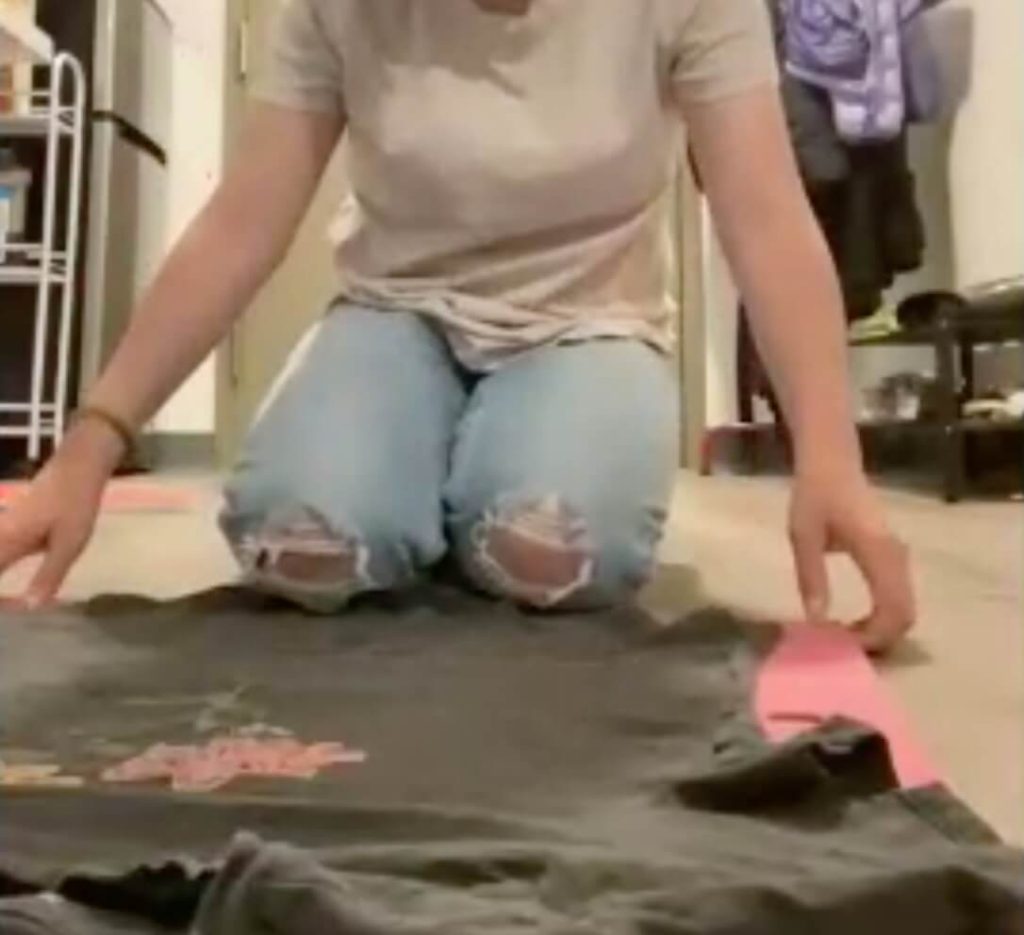 First step of laying a gray shirt out over the flip and fold