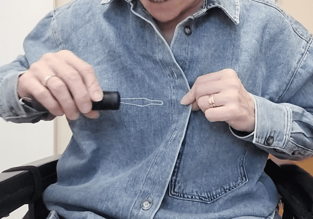 Button hook being inserted into button hole